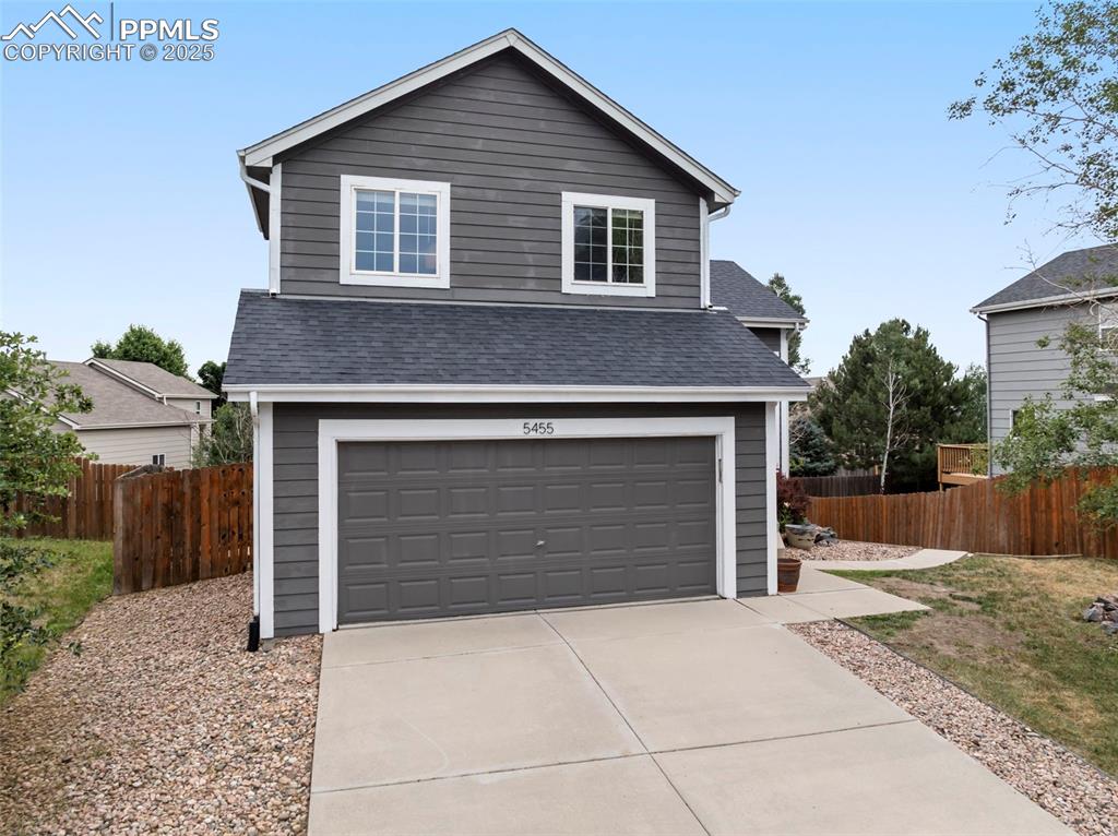 Image 28 of 31: View of front of house with a garage, concrete driveway, and roof with shin