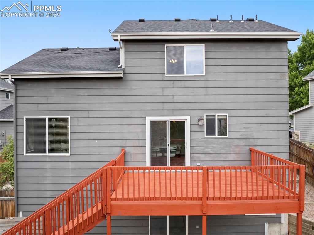 Image 29 of 31: Back of property featuring a wooden deck, roof with shingles, and stairs