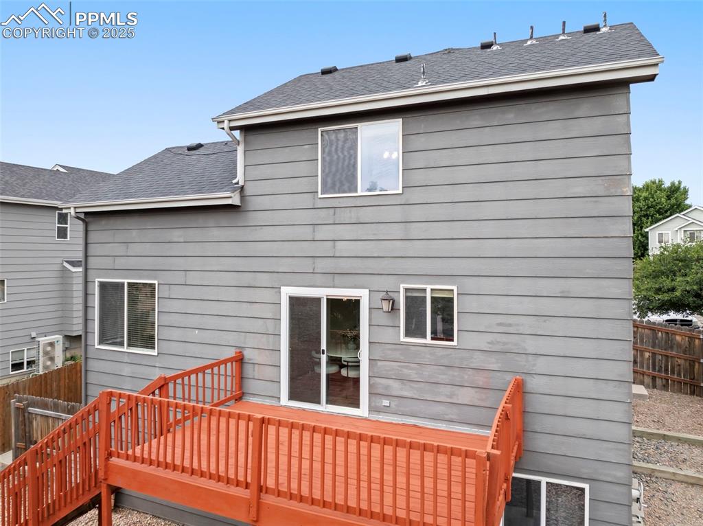 Image 31 of 31: Rear view of house featuring a shingled roof and a deck