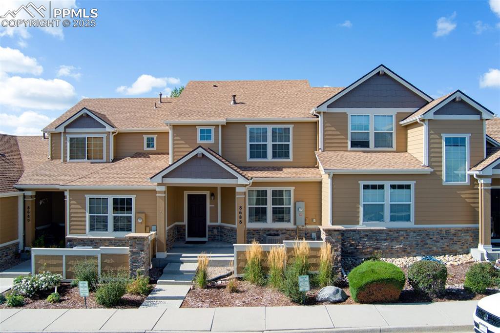 Image 16 of 24: Craftsman inspired home featuring roof with shingles, stone siding, and cov