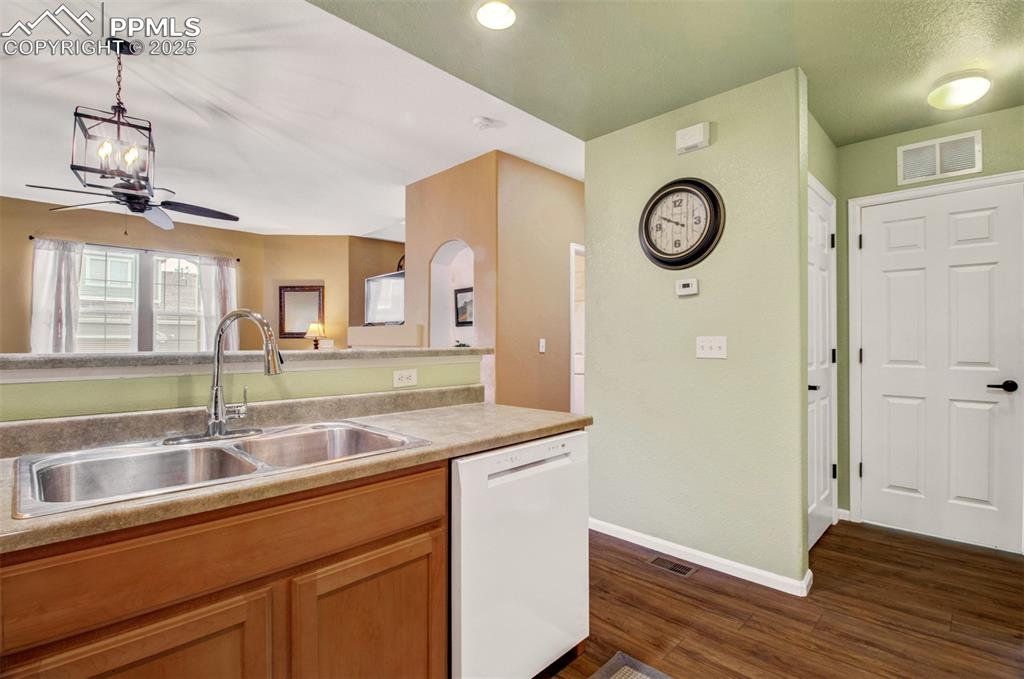 Image 18 of 24: Kitchen featuring new dishwasher, light countertops, new flooring, hanging