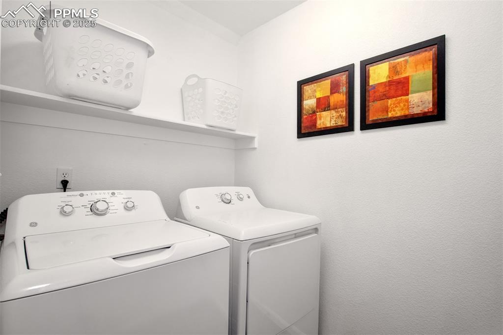 Image 19 of 24: Main level laundry area with washer and clothes dryer that are included