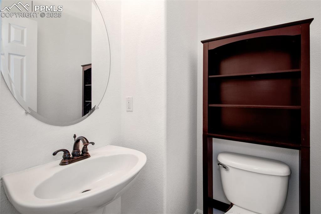 Image 20 of 24: Guest half bathroom featuring a sink and toilet on the main level