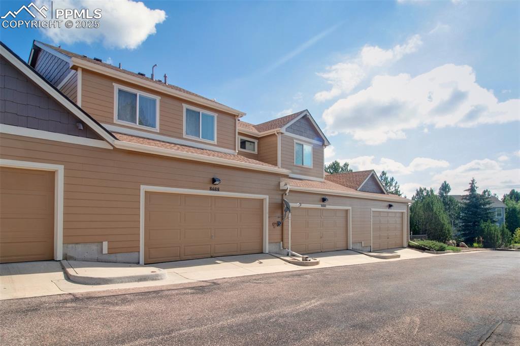 Image 22 of 24: Garage view of the back of the townhome