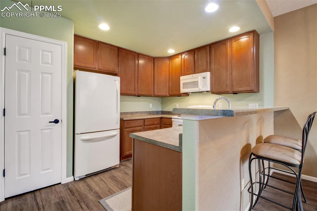 Image 3 of 24: Kitchen with white appliances, new dishwasher, recessed lighting, a breakfa