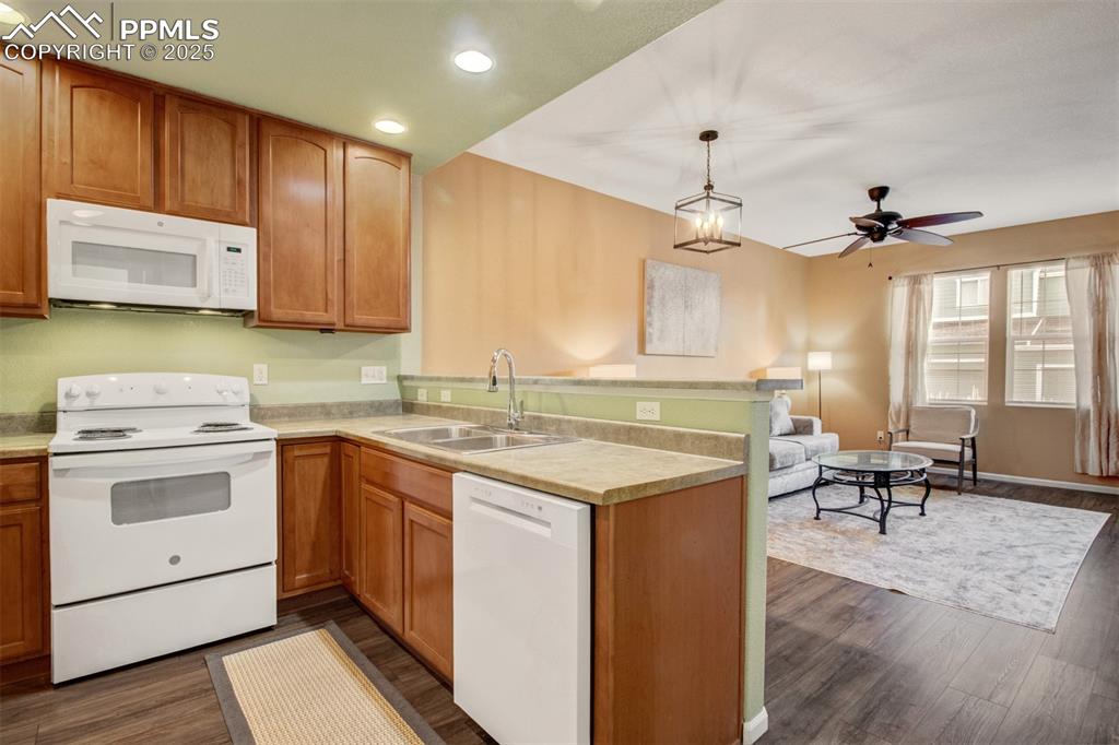 Image 4 of 24: Kitchen with white appliances, new flooring, fresh paint, recessed lighting