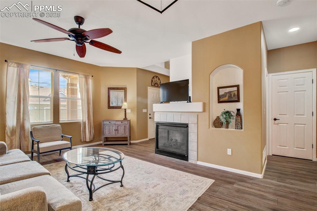 Image 5 of 24: Living area featuring a fireplace, new flooring, and ceiling fan