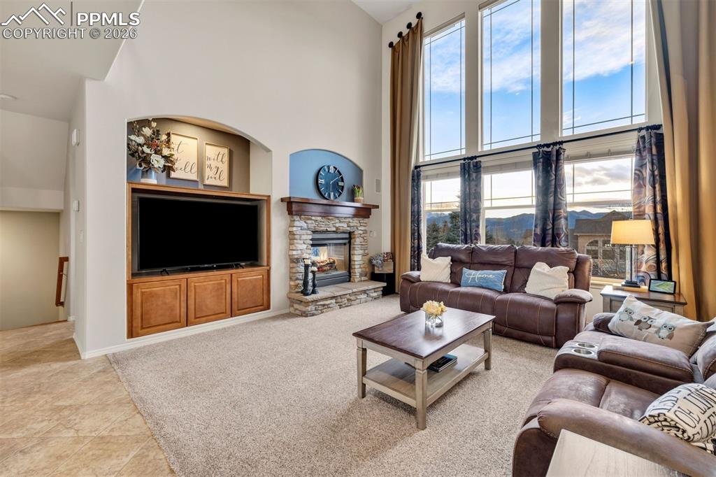 Image 2 of 50: Soaring ceilings and a wall of windows flood the room with natural light 