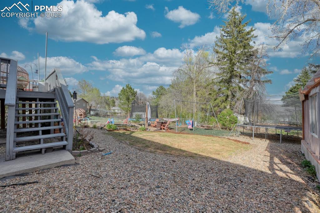 Image 23 of 34: View of yard featuring stairway and a trampoline