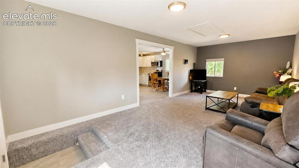 Image 14 of 31: Carpeted living area with recessed lighting and a window