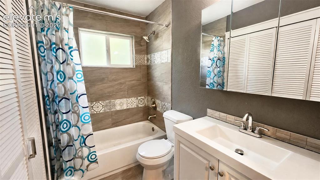 Image 18 of 31: Bathtub with surrounding tile, single window, upgraded sink, chrome-finish