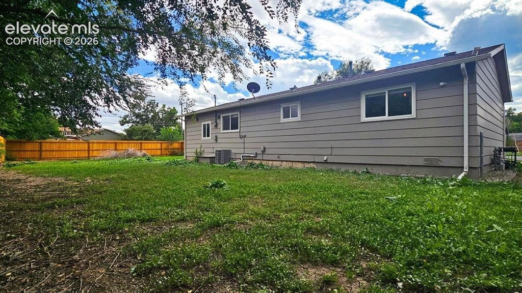 Image 25 of 31: Expansive backyard featuring a wood privacy fence
