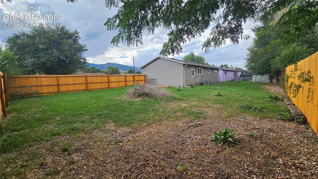 Image 26 of 31: Expansive backyard featuring a wood privacy fence
