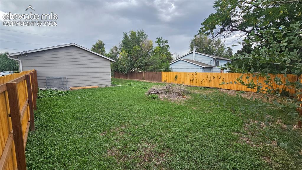 Image 27 of 31: Expansive backyard featuring a wood privacy fence