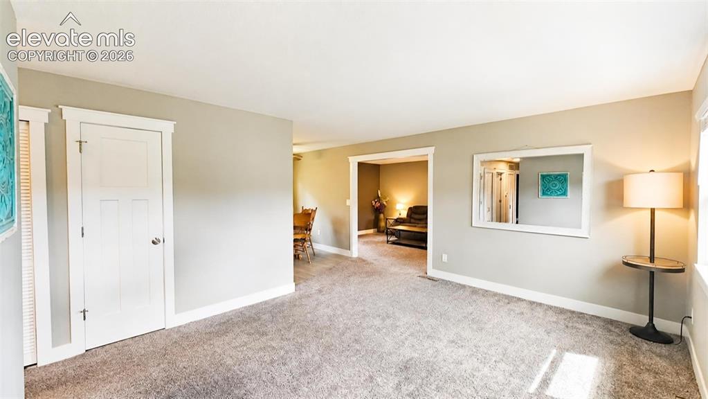 Image 3 of 31: Spacious entry featuring light gray wall paint, and gray carpeted flooring