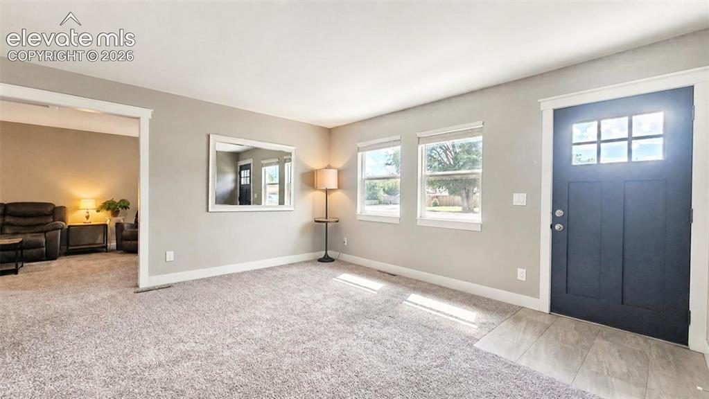 Image 4 of 31: Spacious entry featuring a dark-paneled door with upper glass inserts, two 