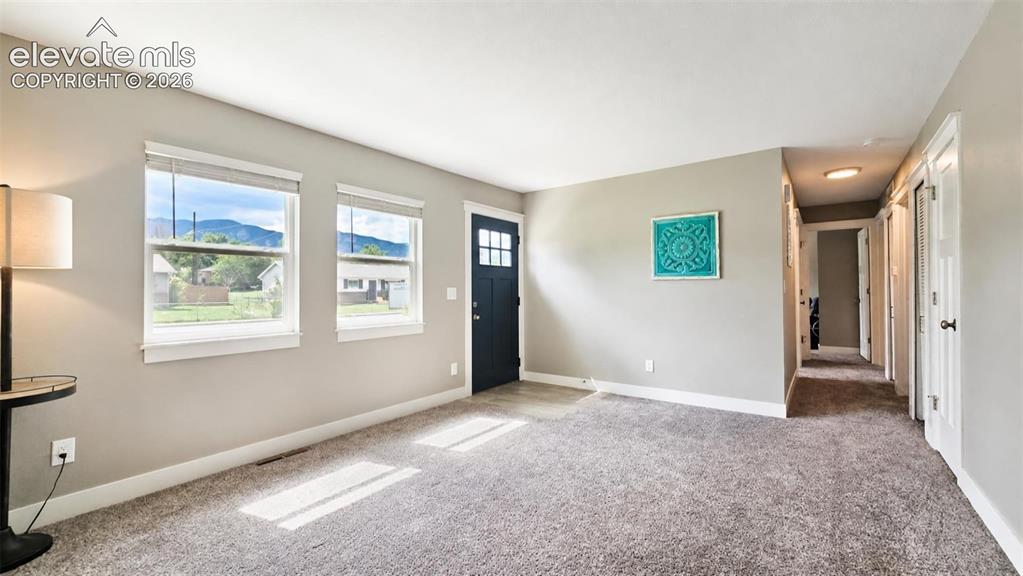 Image 5 of 31: Spacious entry featuring a dark-paneled door with upper glass inserts, two
