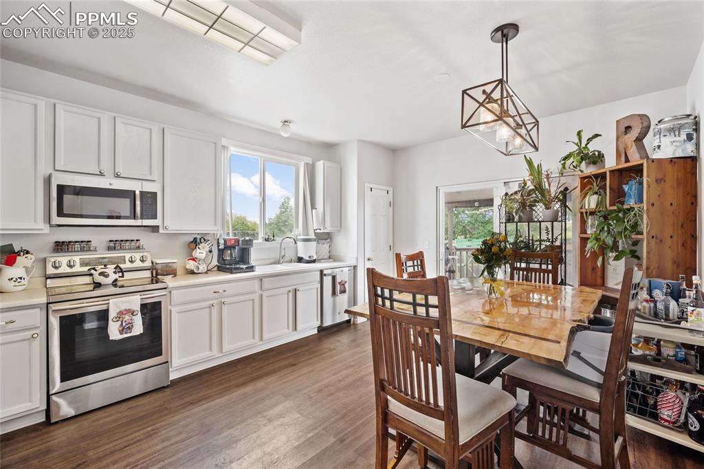 Image 10 of 44: Dining area featuring healthy amount of natural light, dark wood-style floo