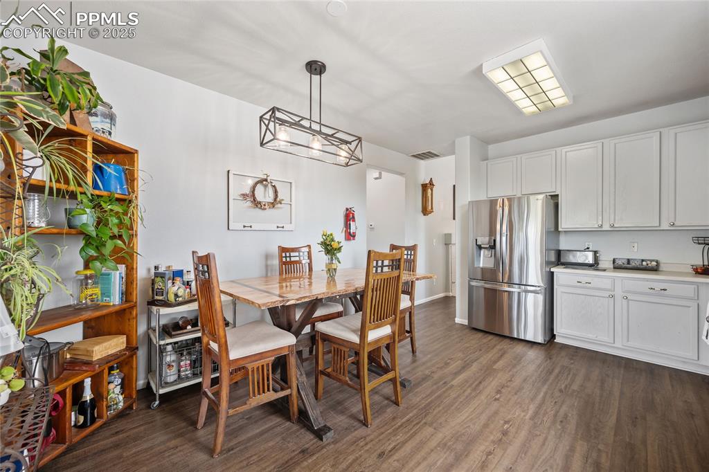 Image 11 of 44: Dining space featuring dark wood finished floors and baseboards