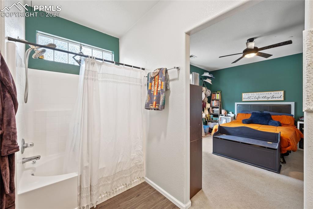 Image 18 of 44: Bathroom featuring shower / tub combo with curtain, a ceiling fan, baseboar