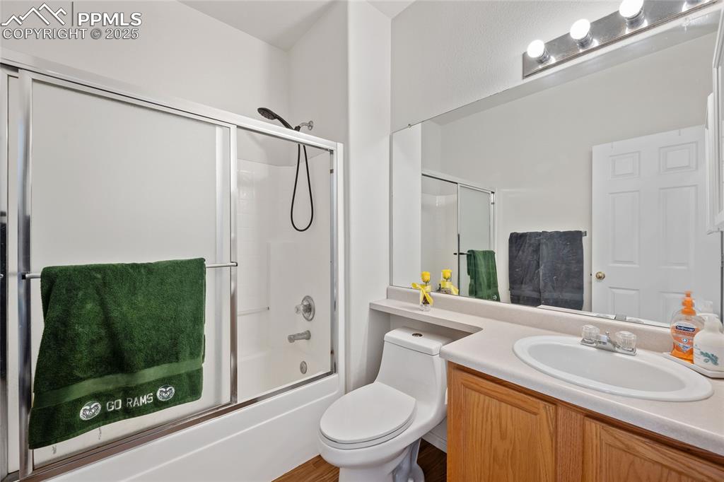 Image 22 of 44: Full bathroom with enclosed tub / shower combo, vanity, and toilet