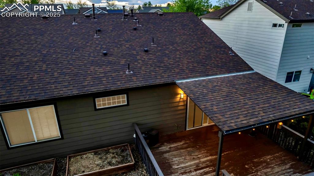Image 31 of 44: View of side of home featuring a shingled roof