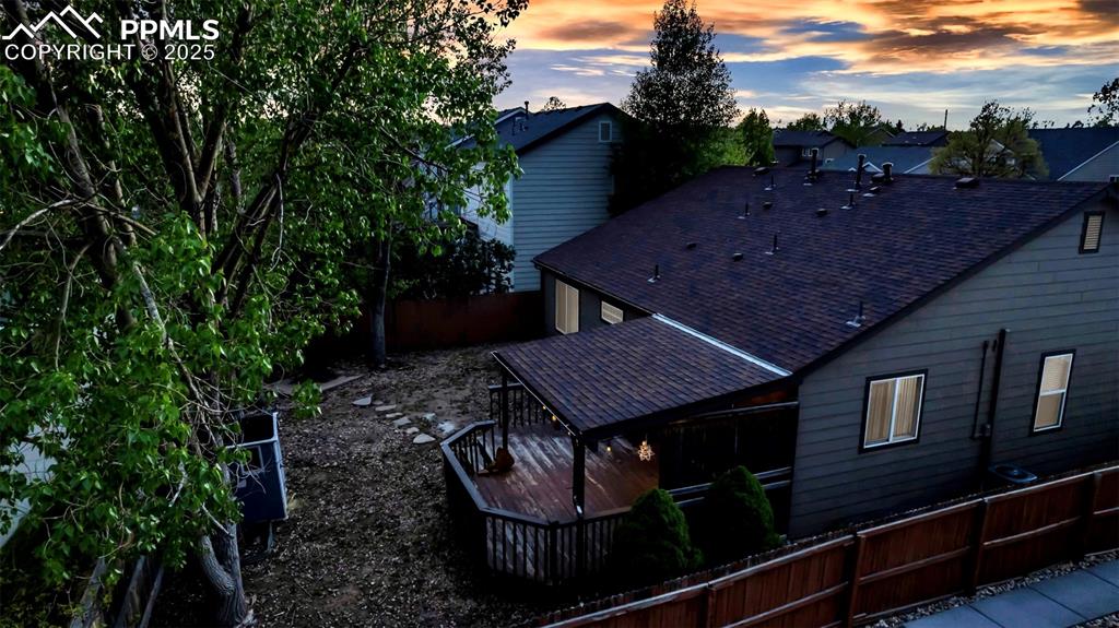 Image 32 of 44: Back of house at dusk with roof with shingles