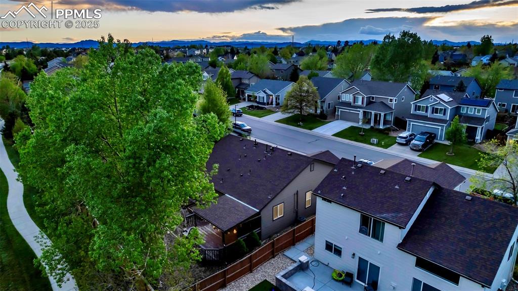 Image 33 of 44: Aerial view at dusk of a residential view and a mountain view