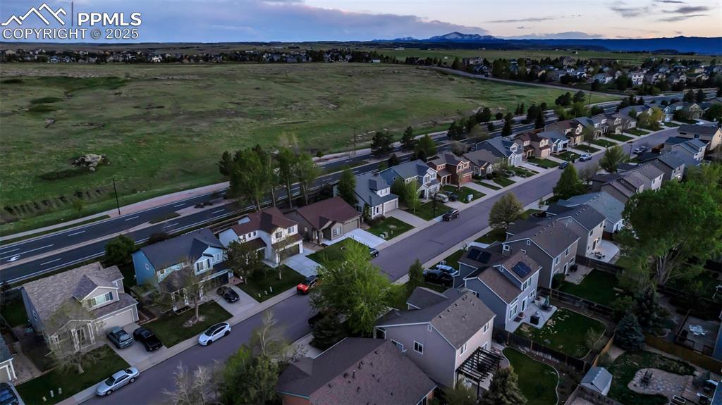Image 35 of 44: Aerial view at dusk of a residential view and a mountain view