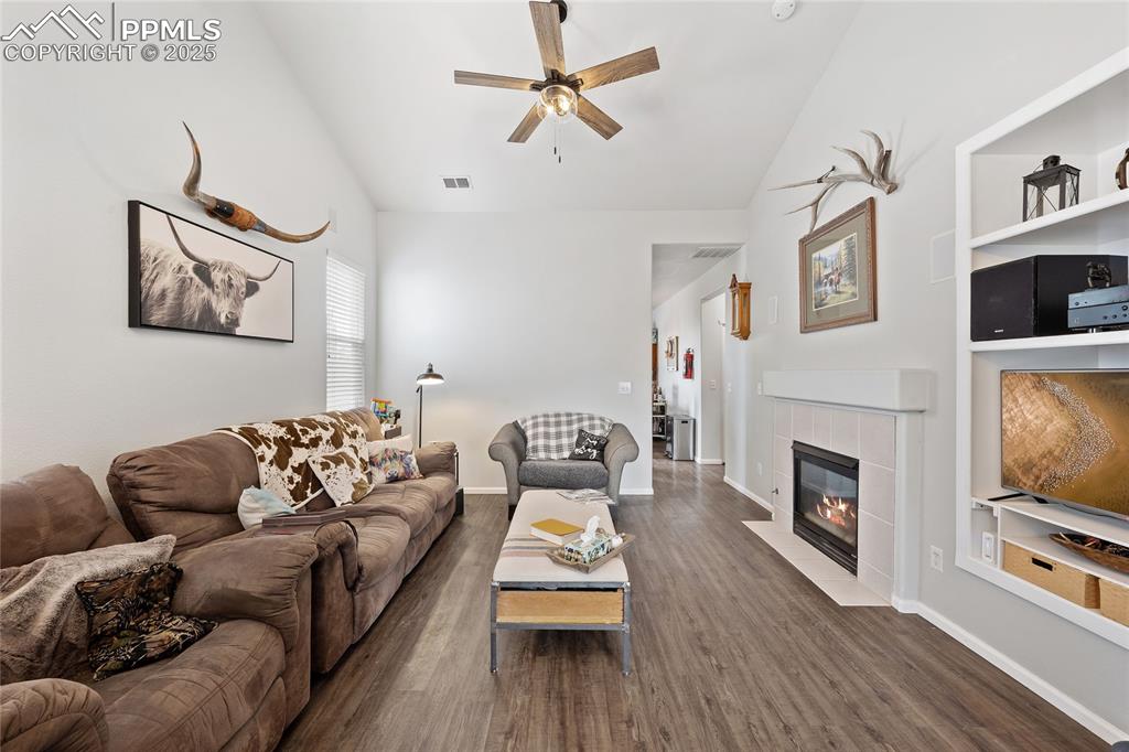 Image 6 of 44: Living room featuring lofted ceiling, ceiling fan, wood finished floors, a 
