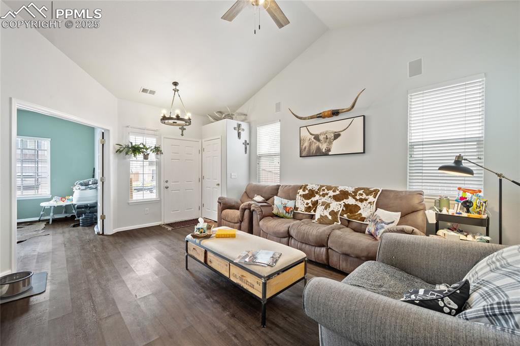 Image 8 of 44: Living room with a chandelier, dark wood-type flooring, a ceiling fan, high