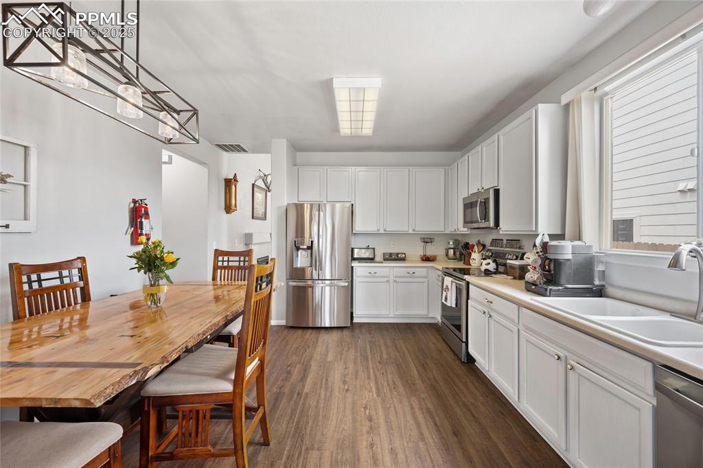 Image 9 of 44: Kitchen featuring stainless steel appliances, a sink, dark wood-style floor