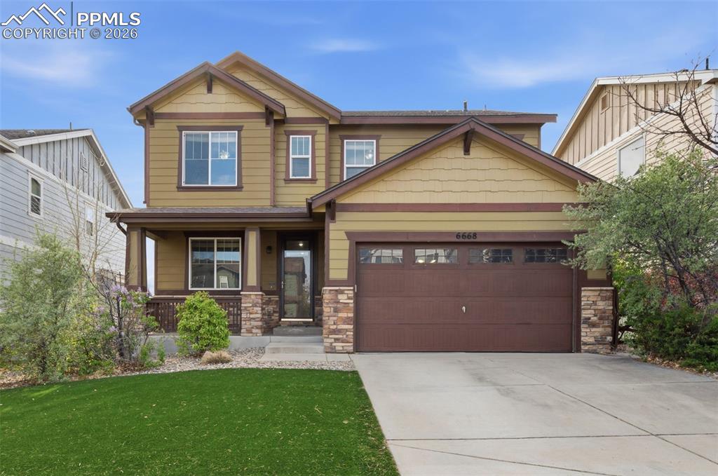 Caption: Two-story residence featuring a covered front porch with stone accents, a two-car garage, and a conc