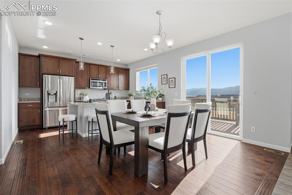Image 10 of 49: Open-concept living area featuring rich wood-finish flooring, a kitchen wit