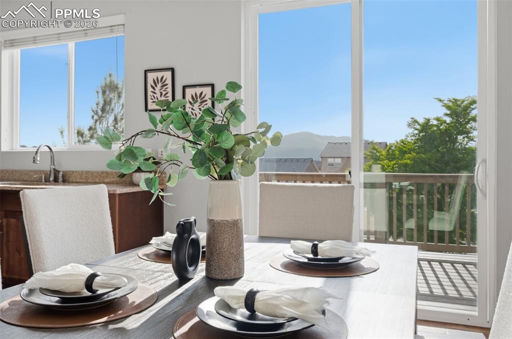 Image 11 of 49: Dining area featuring a sliding glass door to an outdoor deck, a kitchen wi