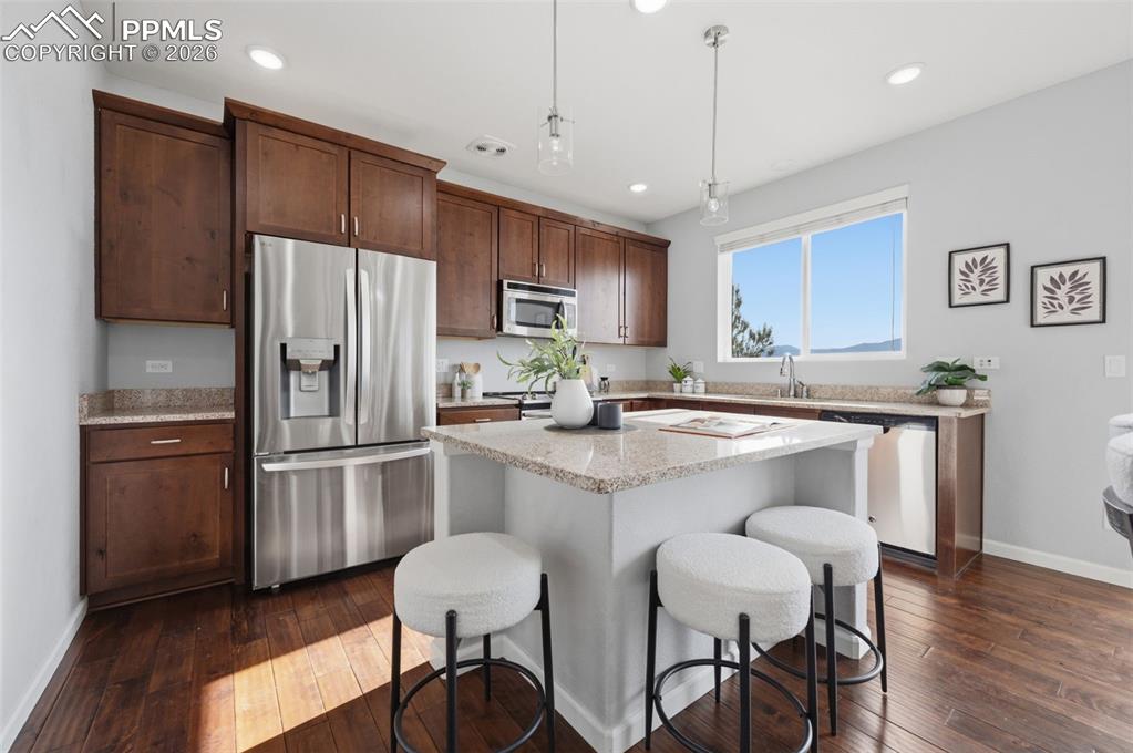 Image 13 of 49: Kitchen featuring a central island with countertop, wood-finish flooring, r