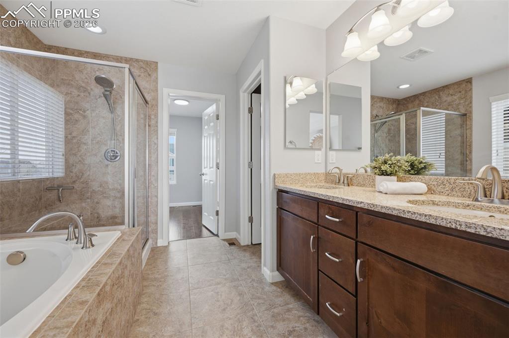 Image 22 of 49: Dual vanity with granite-style countertops and undermount sinks
