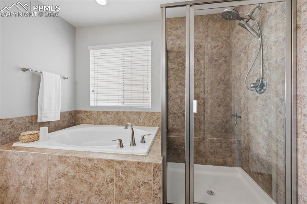 Image 23 of 49: Bathroom featuring a built-in tub with brushed nickel fixtures, a standalon