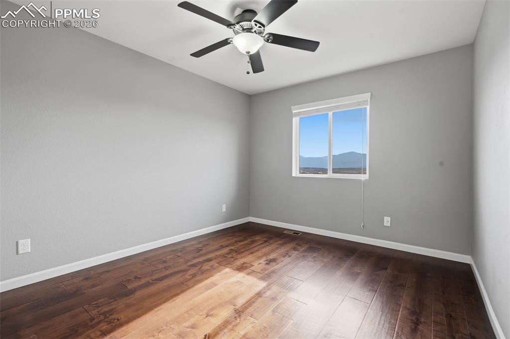 Image 26 of 49: Spacious room featuring wood-finish flooring, light gray walls, and a ceili
