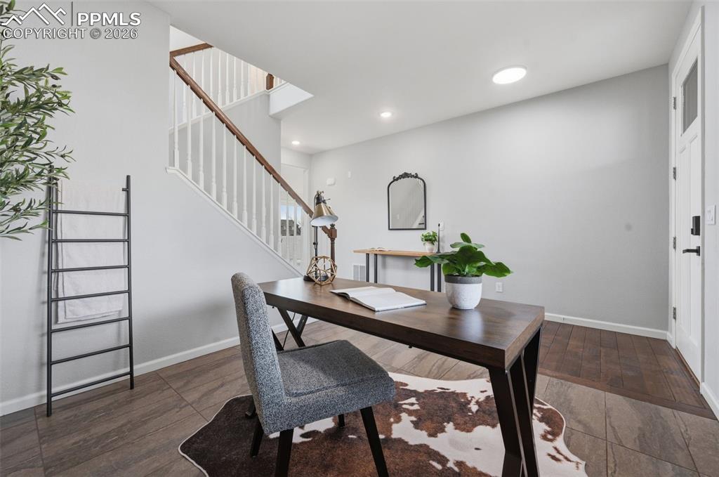 Image 3 of 49: Versatile room featuring wood-finish flooring, a contemporary staircase wit