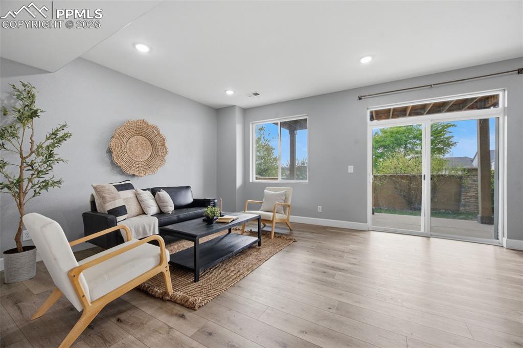 Image 34 of 49: Spacious living area featuring wood-finish flooring, recessed lighting, and
