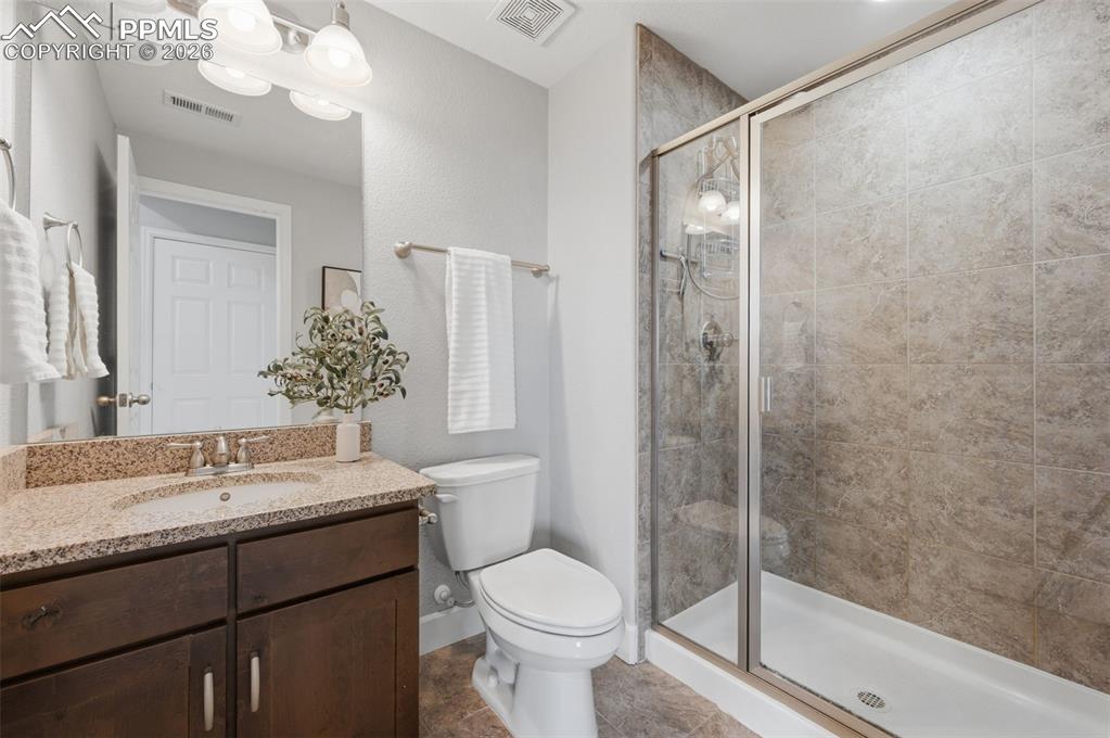 Image 40 of 49: Bathroom featuring a walk-in shower with glass enclosure, single vanity wit