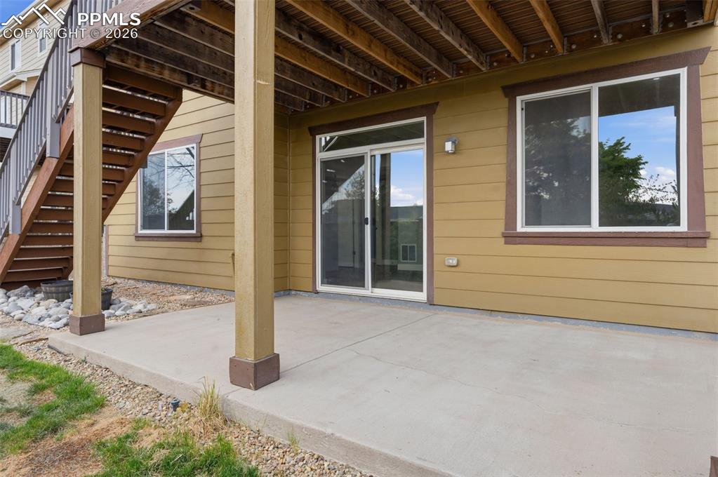 Image 44 of 49: Expansive concrete patio offering direct outdoor access through a sliding g