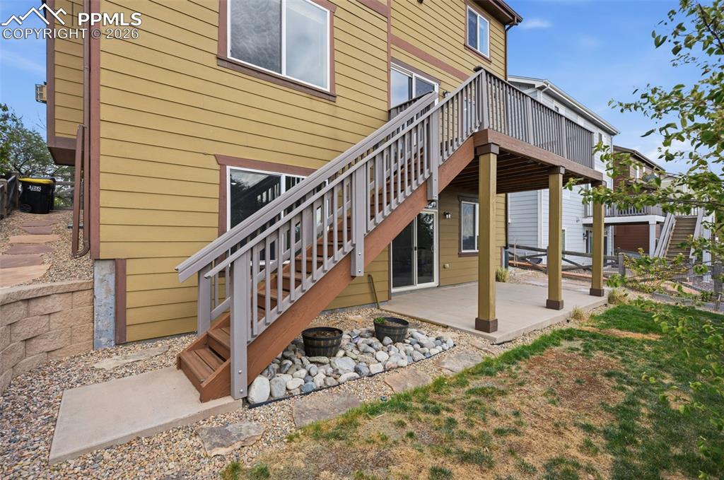 Image 45 of 49: Rear exterior featuring a multi-level deck with wood-finish railings, a con