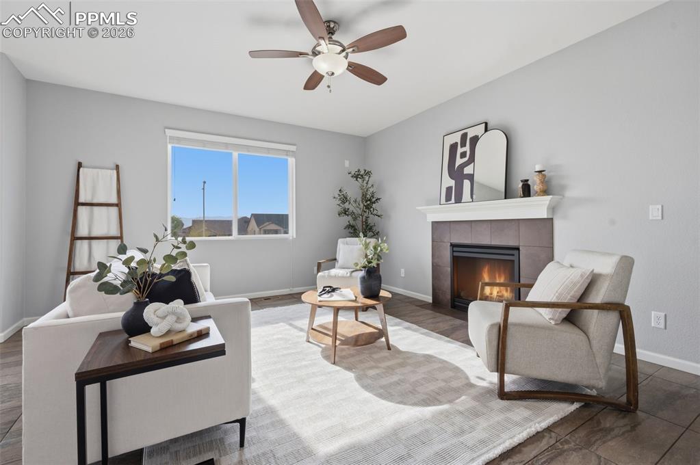 Image 5 of 49: Living area featuring a fireplace with a tiled surround, a white mantel, an