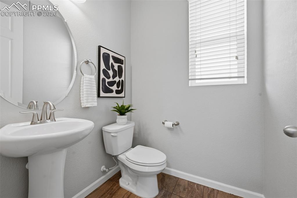 Image 9 of 49: Powder room featuring a pedestal sink with brushed nickel faucet, an oval w