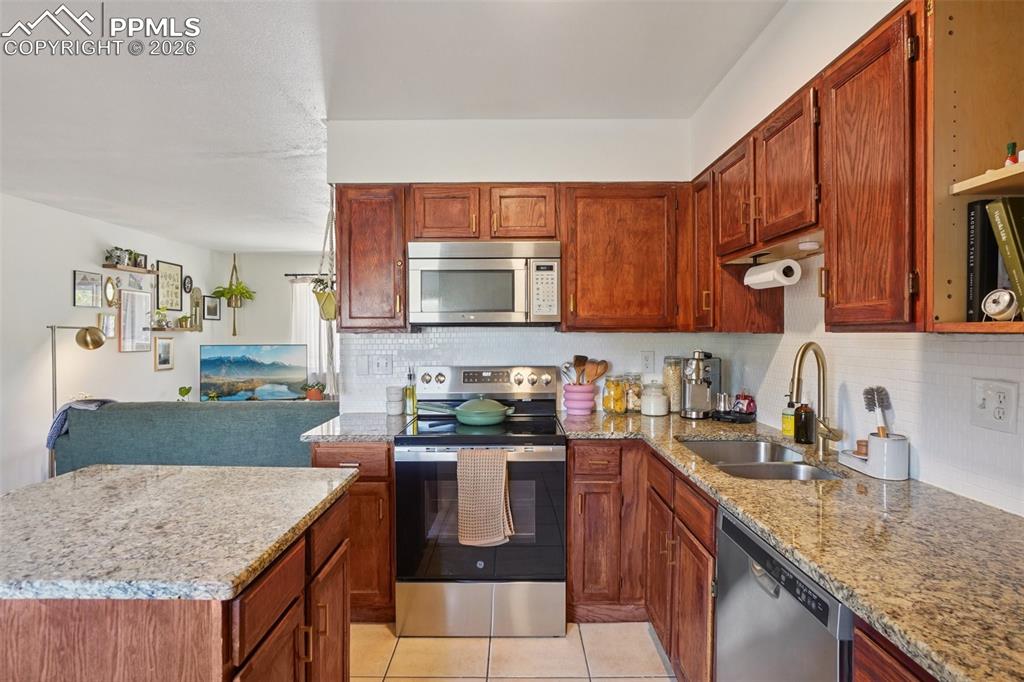 Image 24 of 38: Kitchen with island, dual sink, granite countertops and newer appliances.