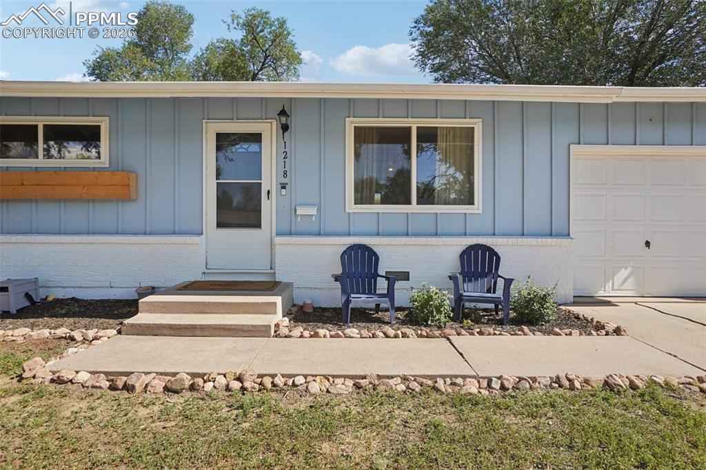 Image 5 of 38: Front entry and sitting area. Notice the built in flower beds to the left