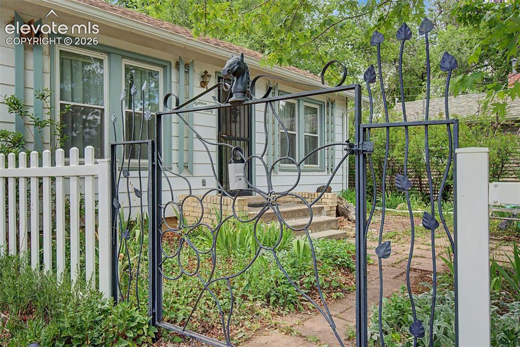 Image 1 of 26: Custom wrought iron gate at entry.