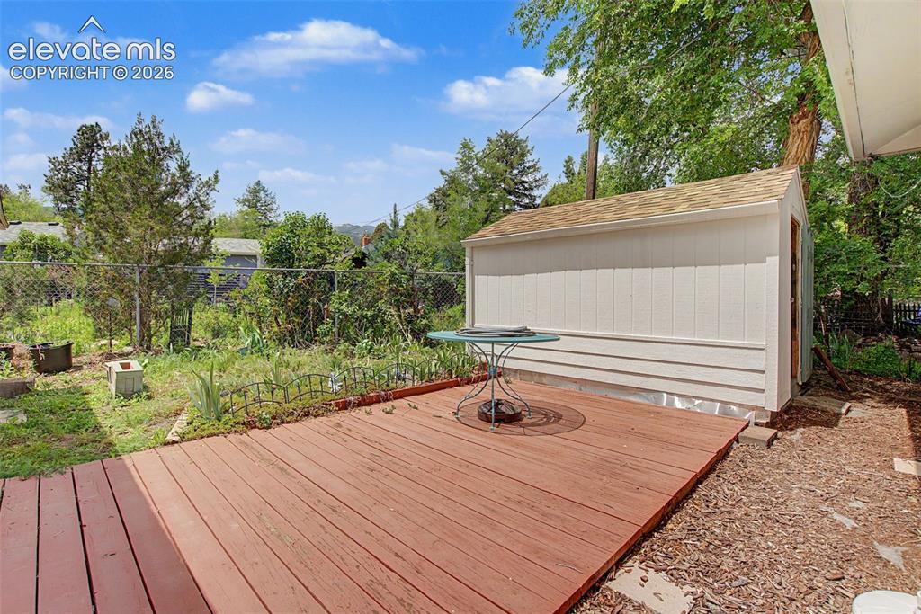 Image 23 of 26: Deck to shop.  No immediate house behind.  Seasonal view of mountains